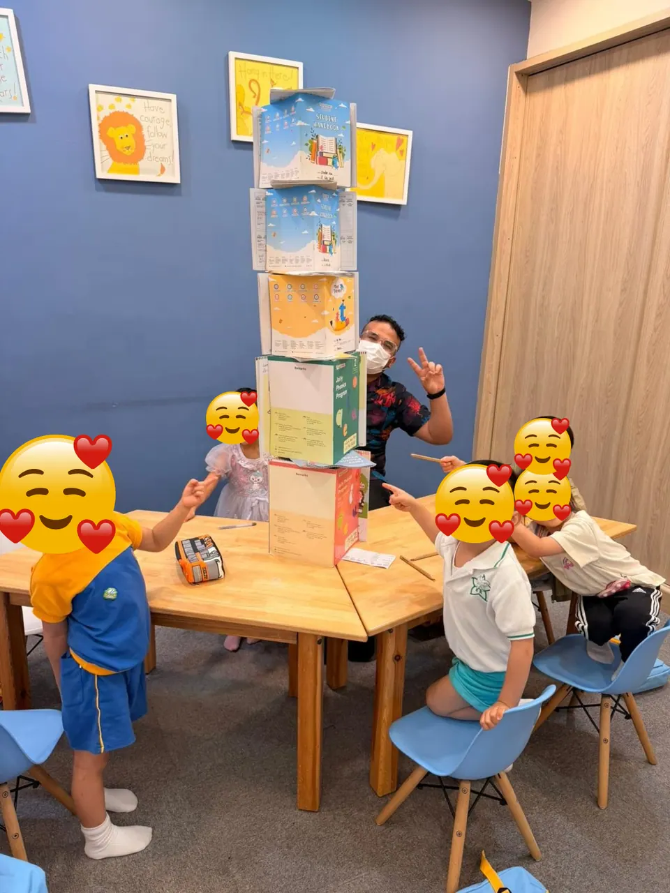 Mr. Nas and students building a tower of learning materials