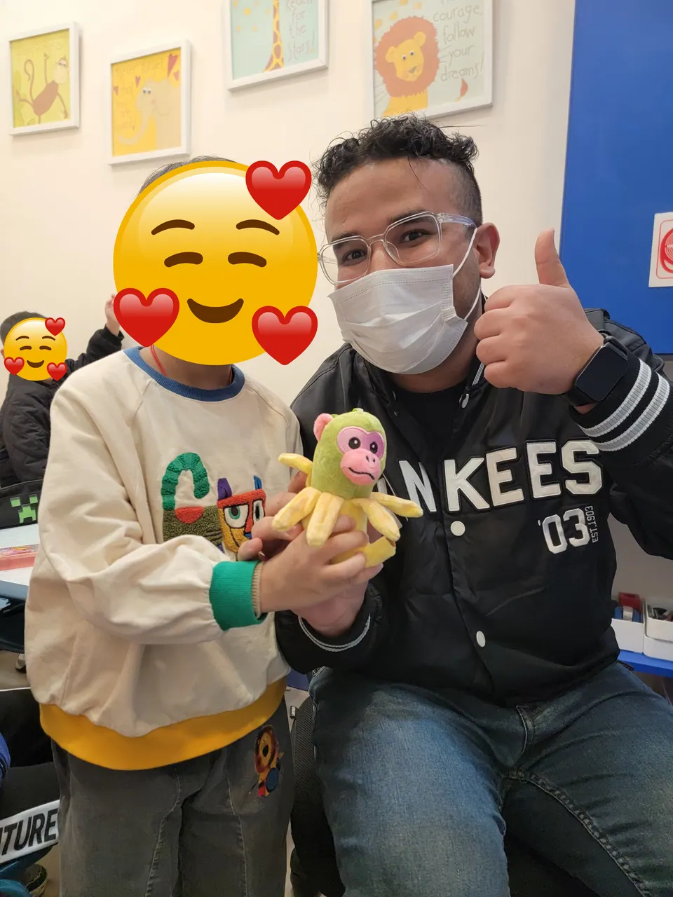 Mr. Nas with a young learner and a classroom toy
